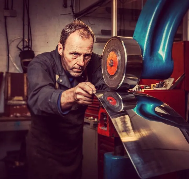 Shaping a body panel on the English wheel in the Julian Parker Ltd workshop